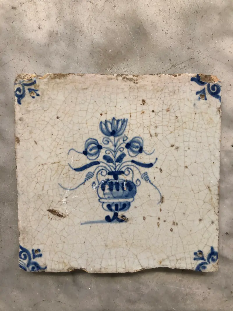 17th century delft tile with flowervase