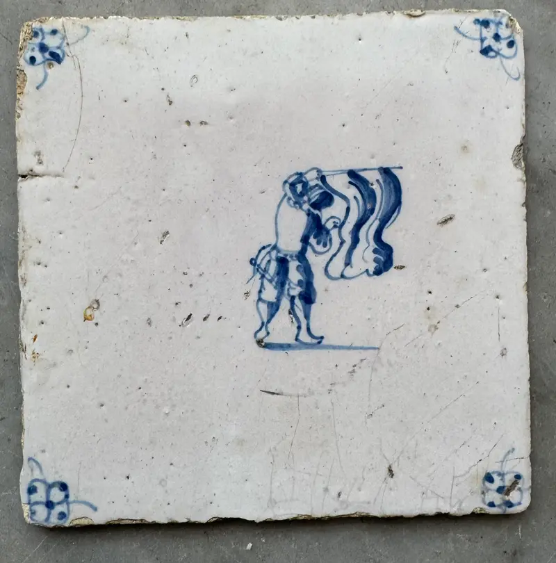 T95)18 th century delft tile with chills playing with a flag